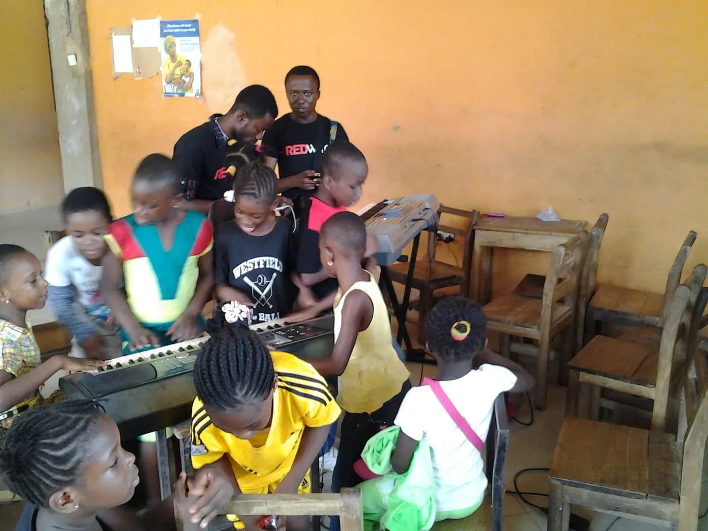 Children crowd two keyboards during a school session · Accra, 28 March 2014