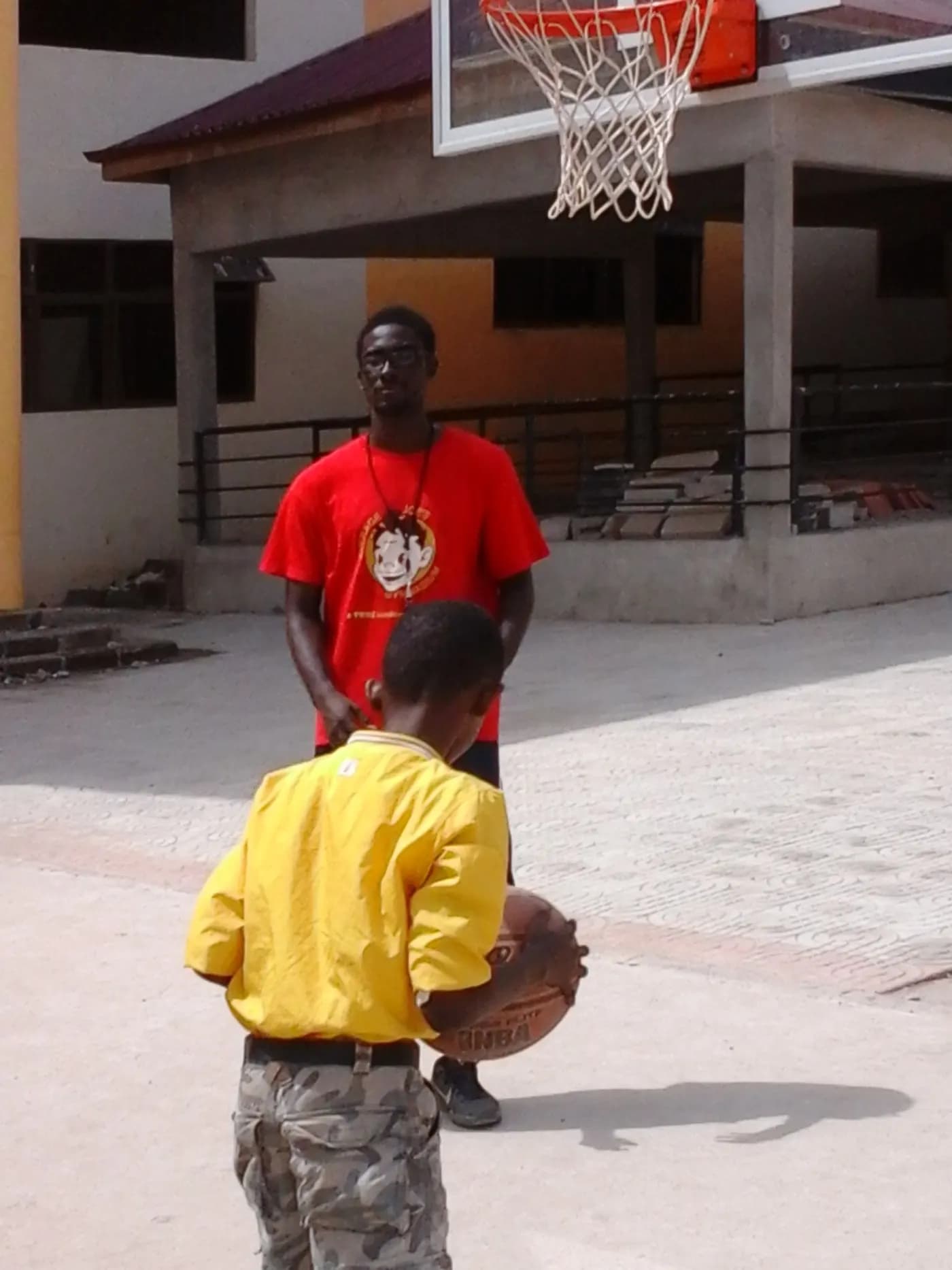 A coach waits while a boy sets his grip · Accra, 5 April 2014