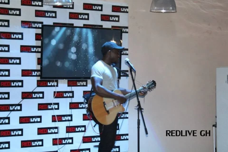 A guitarist plays the room at a Red Friday · Accra